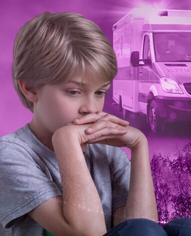 Ein Junge der bedrück aussieht mit einem Krankenwagen im Hintergrund.