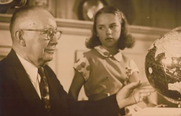 Jesse I. Overholtzer zusammen mit einem Mädchen in einem Raum.